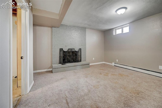 basement with a textured ceiling, carpet floors, a baseboard heating unit, and a brick fireplace