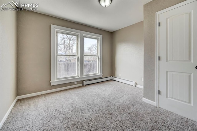 carpeted empty room with baseboard heating