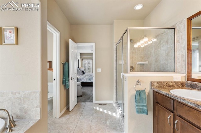 bathroom with tile patterned floors, vanity, a shower with shower door, and toilet