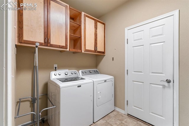 laundry area featuring washer and clothes dryer and cabinets