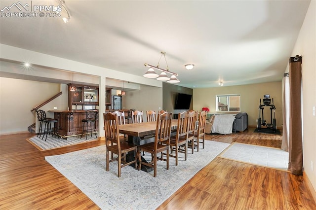 dining room featuring bar area and wood-type flooring