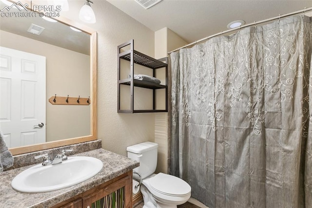 bathroom with a shower with curtain, vanity, and toilet