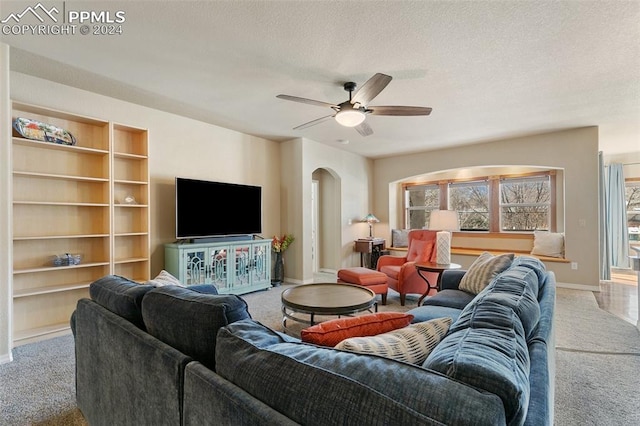 carpeted living room featuring a textured ceiling and ceiling fan