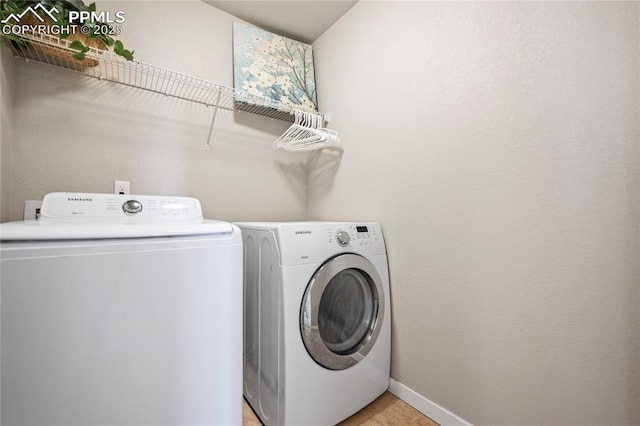 laundry room featuring washing machine and clothes dryer and light tile patterned flooring