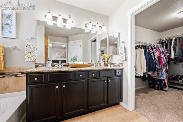 bathroom with tile patterned floors, vanity, a tub, and a textured ceiling