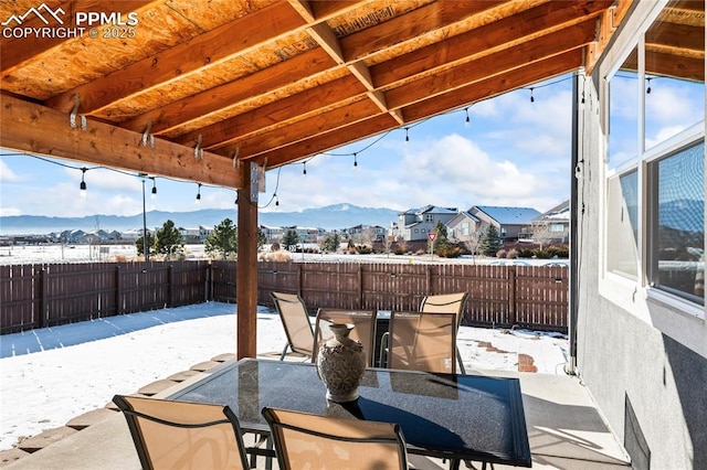 snow covered patio with a mountain view