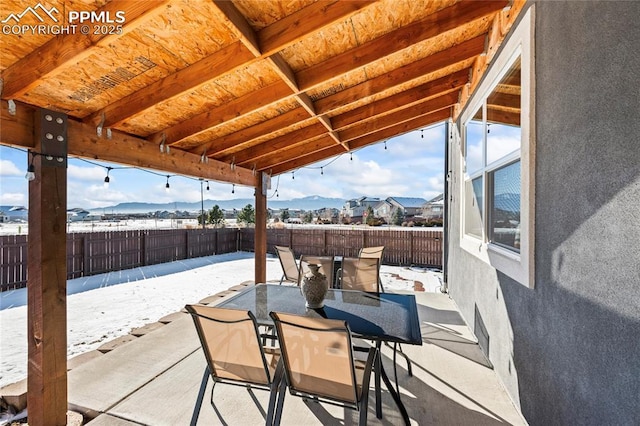 snow covered patio with a mountain view