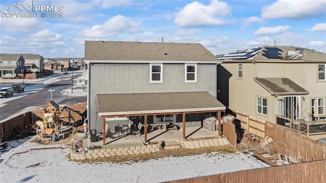 snow covered house featuring a patio