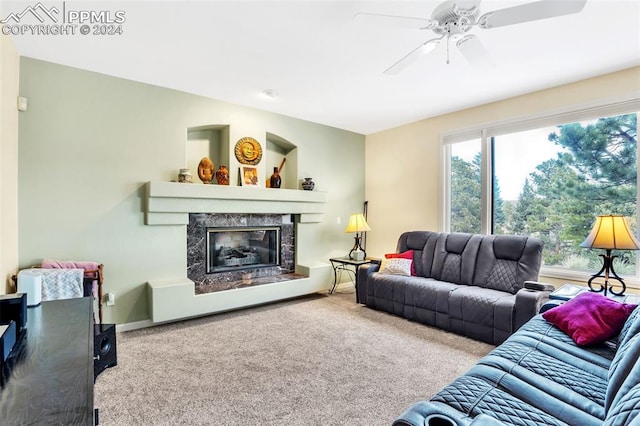 living room with carpet flooring, ceiling fan, and a fireplace