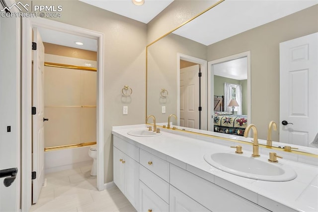 full bathroom with tile patterned floors, vanity, toilet, and enclosed tub / shower combo