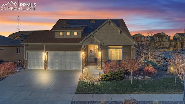 view of front of home with a garage and solar panels