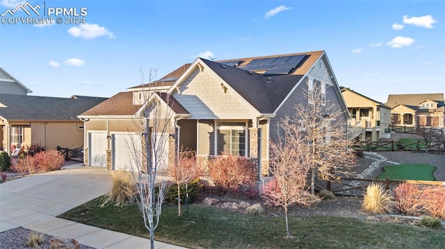 view of front of home with a garage, a front lawn, and solar panels