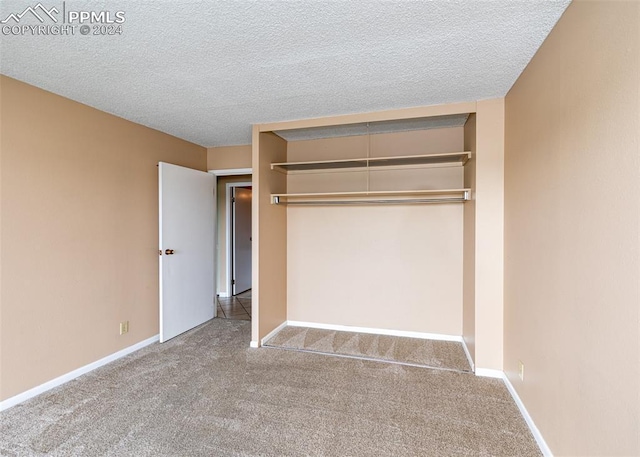 unfurnished bedroom featuring carpet flooring, a textured ceiling, and a closet