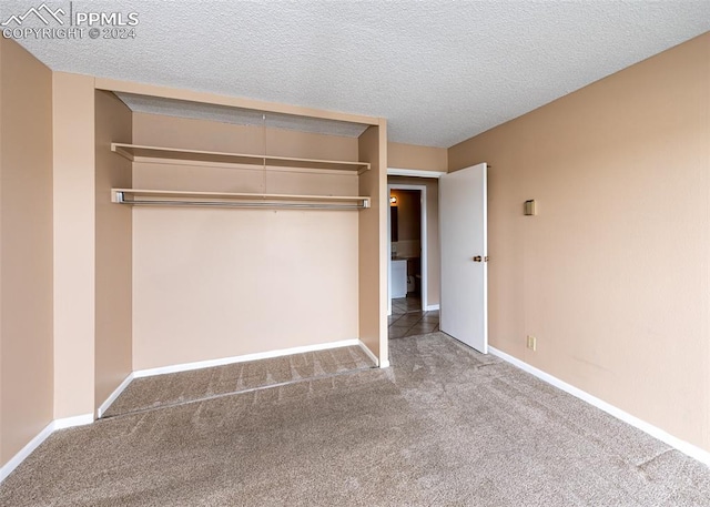 unfurnished bedroom with carpet floors, a textured ceiling, and a closet