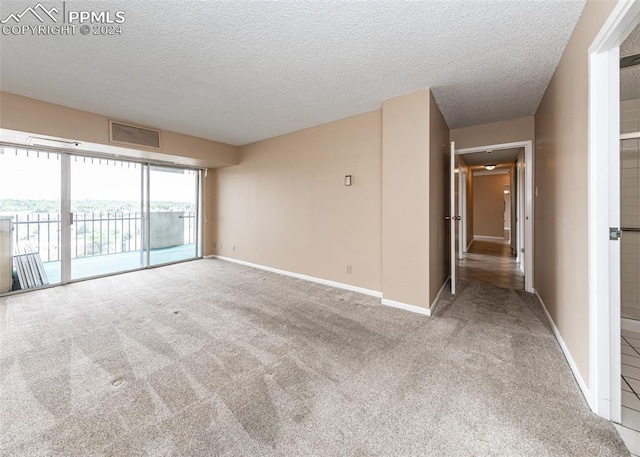 spare room featuring a textured ceiling and carpet floors