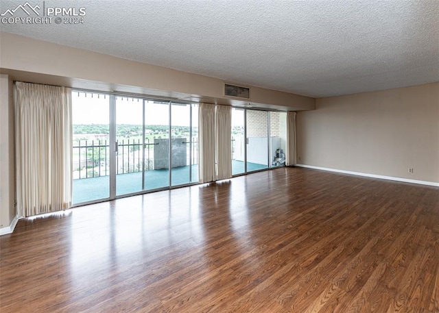 spare room featuring hardwood / wood-style floors and a textured ceiling