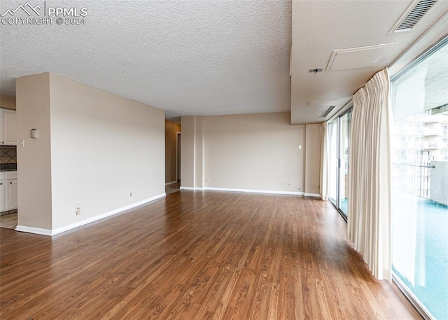 spare room with light hardwood / wood-style flooring and a textured ceiling