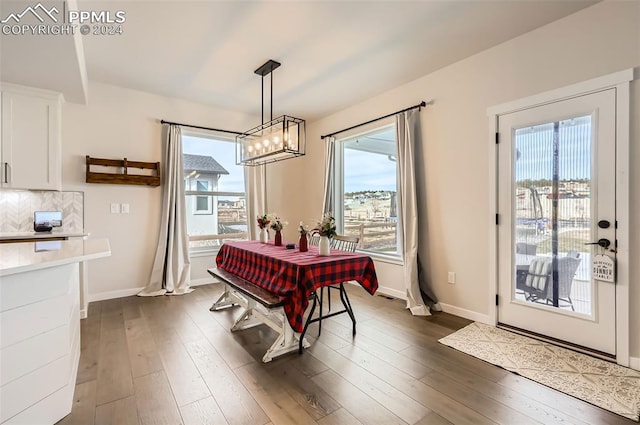 dining space with a notable chandelier, dark wood-type flooring, and a wealth of natural light