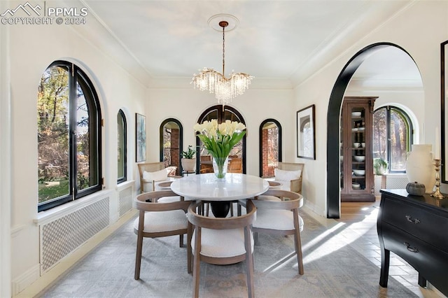 dining room with a wealth of natural light, crown molding, and a notable chandelier