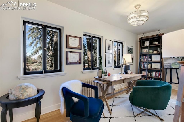 home office featuring light wood-type flooring, radiator heating unit, and a chandelier