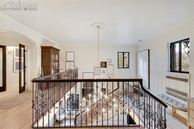 hall with light wood-type flooring and crown molding