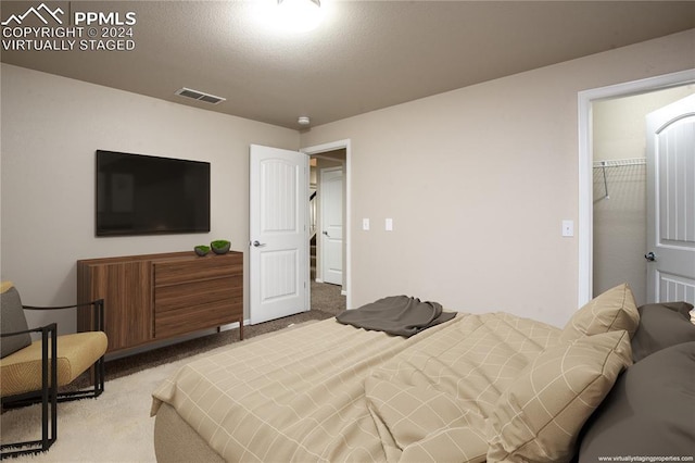 bedroom with a spacious closet, a closet, and carpet