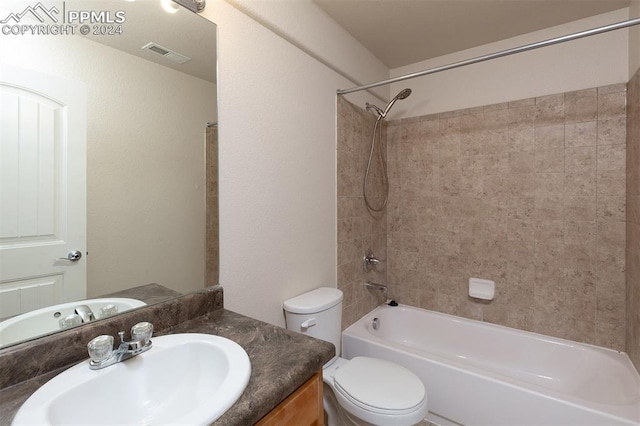 full bathroom with vanity, tiled shower / bath combo, and toilet