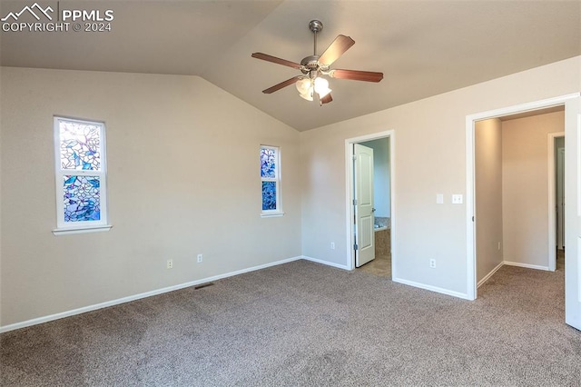 unfurnished bedroom featuring multiple windows, ceiling fan, light colored carpet, and vaulted ceiling