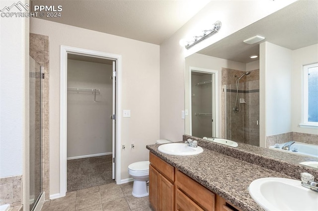 full bathroom featuring vanity, tile patterned flooring, separate shower and tub, toilet, and a textured ceiling