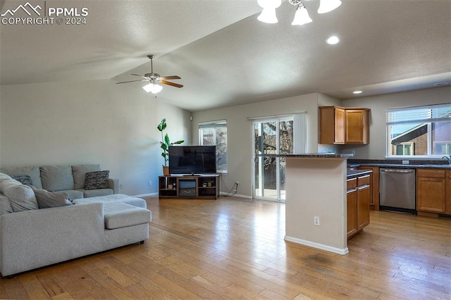 kitchen with dishwasher, ceiling fan with notable chandelier, sink, vaulted ceiling, and light hardwood / wood-style floors