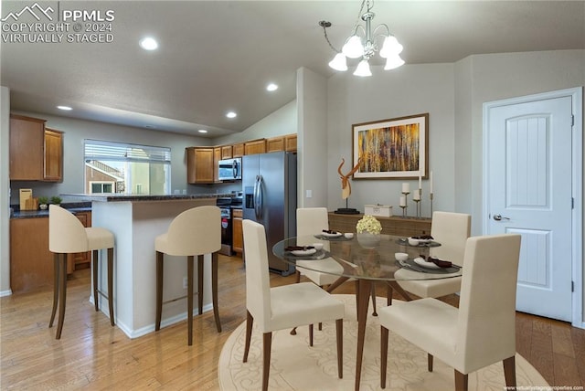 dining area featuring a notable chandelier, light hardwood / wood-style floors, and lofted ceiling