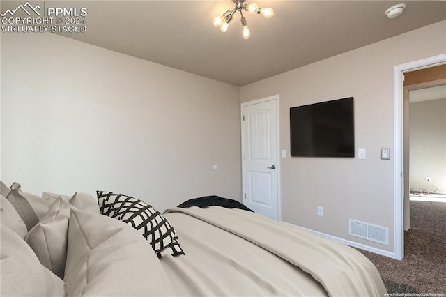 carpeted bedroom featuring an inviting chandelier