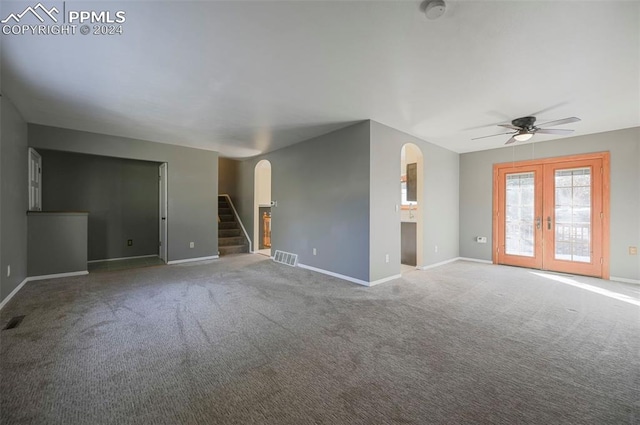 unfurnished living room with carpet flooring, ceiling fan, and french doors