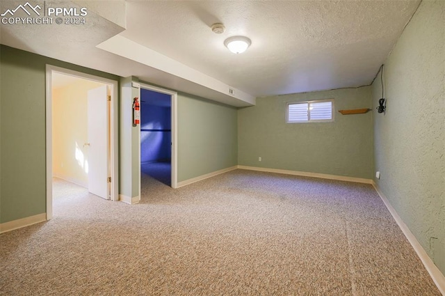 basement featuring carpet floors and a textured ceiling