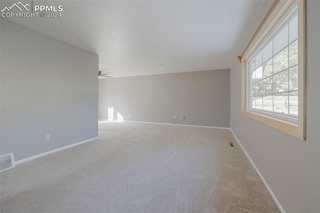 carpeted spare room with ceiling fan