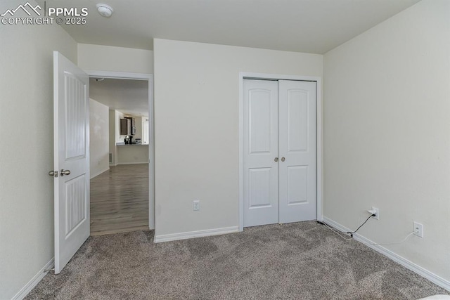 unfurnished bedroom featuring carpet and a closet