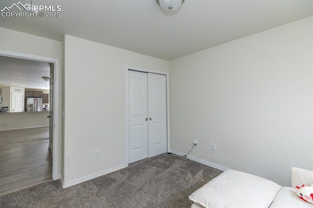 carpeted bedroom with stainless steel refrigerator, a closet, and radiator