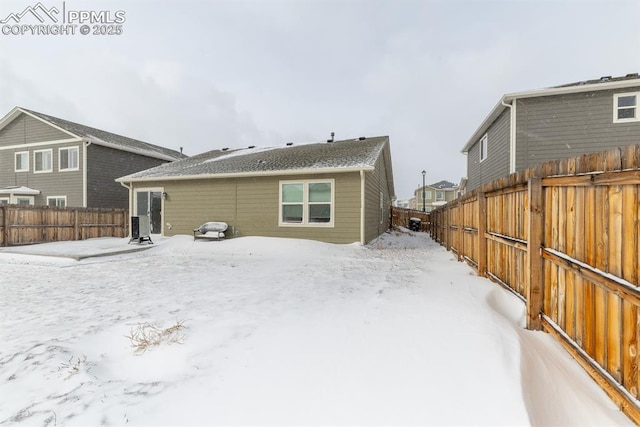 view of snow covered back of property