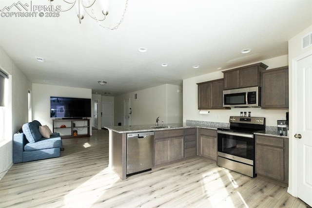 kitchen with sink, stainless steel appliances, and light hardwood / wood-style flooring