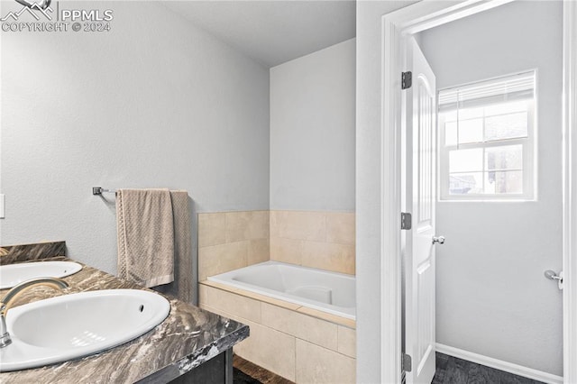 bathroom with vanity and a relaxing tiled tub