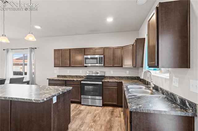 kitchen with sink, hanging light fixtures, dark brown cabinets, light hardwood / wood-style floors, and stainless steel appliances