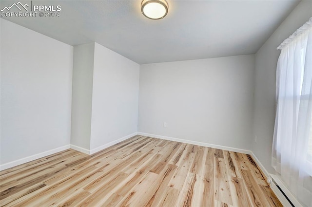 bonus room featuring a baseboard radiator and light hardwood / wood-style flooring