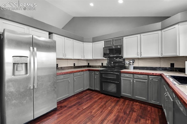 kitchen with gray cabinetry, wood counters, vaulted ceiling, and appliances with stainless steel finishes