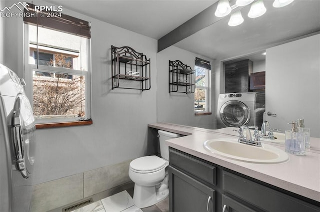 bathroom featuring tile patterned floors, vanity, toilet, and washer / clothes dryer