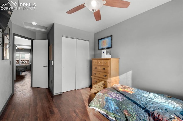 bedroom with a closet, dark wood-type flooring, and ceiling fan