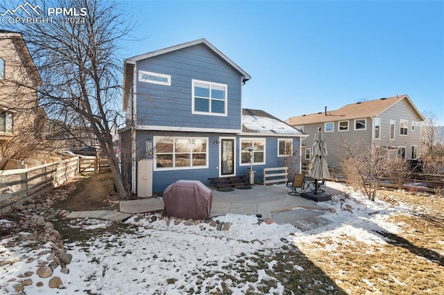 snow covered house with a patio