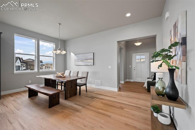 dining room featuring light wood-type flooring and an inviting chandelier