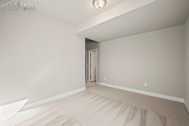 unfurnished room featuring light colored carpet