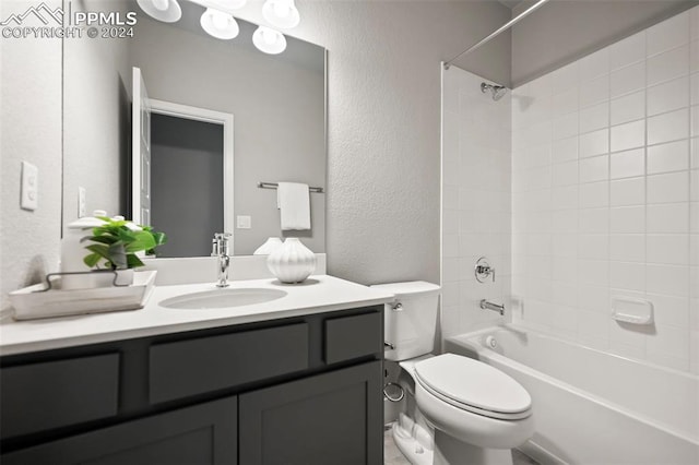 full bathroom featuring vanity, tiled shower / bath combo, and toilet