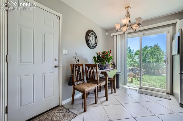 tiled dining space with a wealth of natural light and an inviting chandelier